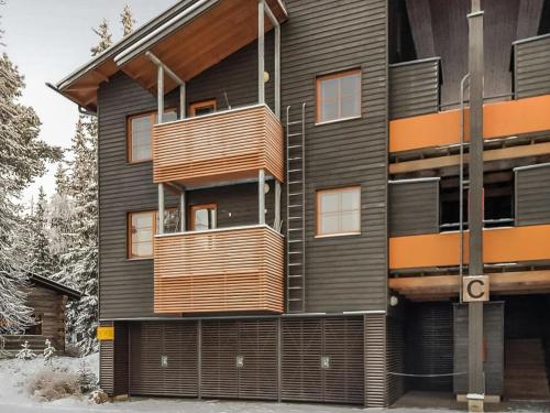 a building with wooden balconies on the side of it at Holiday Home Karhunvartijan linna c17 by Interhome in Ruka