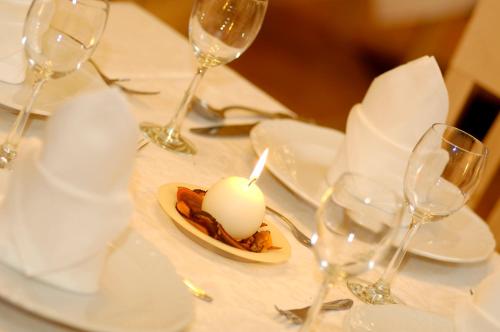 a table with glasses and a plate with a candle on it at Hotel Waldheim in Valle Di Casies