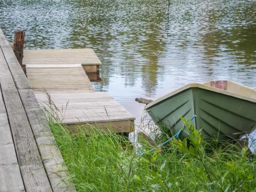 a boat on the water next to a dock at Holiday Home Viehko by Interhome in Lipinlahti