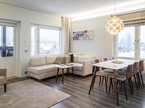 a living room with a couch and a table at Holiday Home Tahko spa red - vuori apartment by Interhome in Tahkovuori
