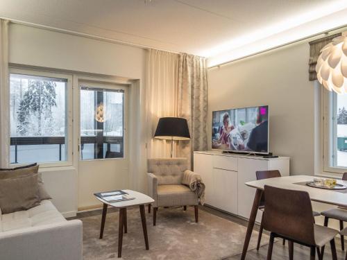 a living room with a white couch and a table at Holiday Home Tahko spa red - golf apartment by Interhome in Tahkovuori