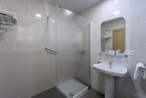 a bathroom with a shower and a sink and a mirror at Hotel Sur Málaga in Málaga