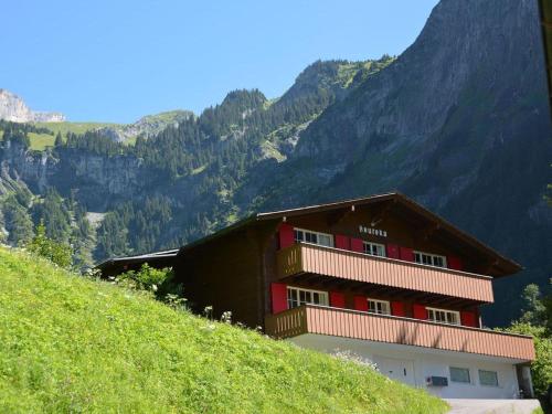 a building on a hill with mountains in the background at Apartment Chalet Heureka-Horbis by Interhome in Engelberg