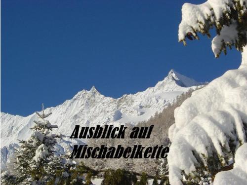 a snow covered mountain with a sign that reads austkritkrit all misifiable at Apartment Chalet Saasia by Interhome in Saas-Fee