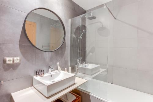 a white bathroom with a sink and a mirror at Sweet Inn - Callao in Barcelona