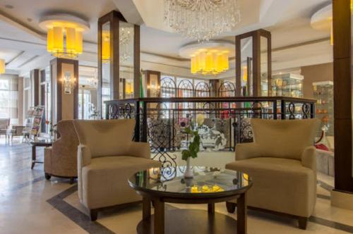 a lobby with chairs and a table and a chandelier at TADJ EL MAOUADA in Sétif