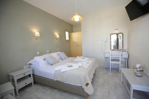 a bedroom with a bed and a table and a mirror at Alexandra's Rooms in Parikia