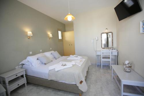 a bedroom with a bed and a table and a mirror at Alexandra's Rooms in Parikia