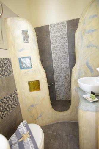 a bathroom with a sink and a toilet and a shower at Alexandra's Rooms in Parikia