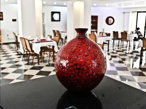 特萊姆森的住宿－STAMBOULI，坐在餐厅桌子上的红色花瓶