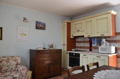 a kitchen with white cabinets and a table and a microwave at B&B La Terrazza Del Subasio in Assisi