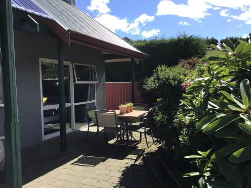 a patio with a table and chairs in a yard at Self contained and private room in Dunedin