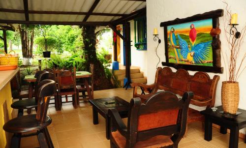 a living room with chairs and a table with a peacock painting at Finca El Jecho in Villavicencio