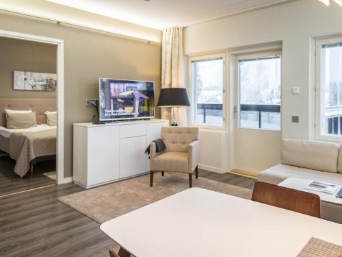 a living room with a tv and a bed and a couch at Holiday Home Tahko spa red - vuori apartment by Interhome in Tahkovuori
