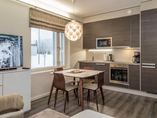 a kitchen and dining room with a table and chairs at Holiday Home Tahko spa red - golf apartment by Interhome in Tahkovuori