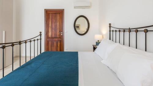 a bedroom with a large bed and a mirror at La Matrangela Charme Apartments in Taormina