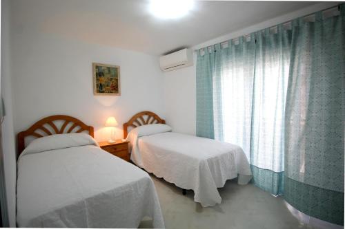 1 dormitorio con 2 camas y ventana en Casa Carretas SpainSunRentals 1050, en Nerja