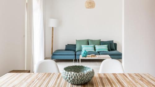 a living room with a blue couch and a table at La Matrangela Charme Apartments in Taormina