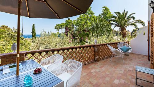 a patio with a table and chairs and an umbrella at La Matrangela Charme Apartments in Taormina