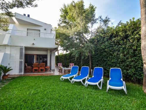 eine Gruppe blauer Stühle, die auf dem Gras sitzen in der Unterkunft Holiday Home Es clot by Interhome in Alcúdia
