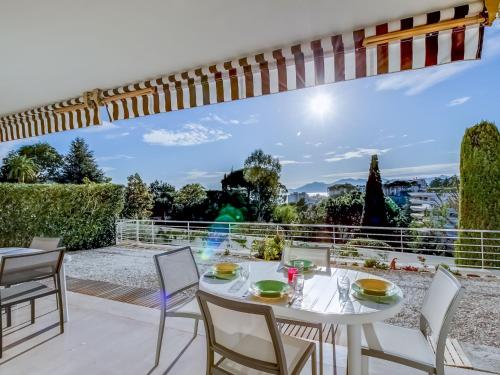 - une table et des chaises blanches sur la terrasse avec vue dans l'établissement Apartment Les Hortensias by Interhome, à Cannes