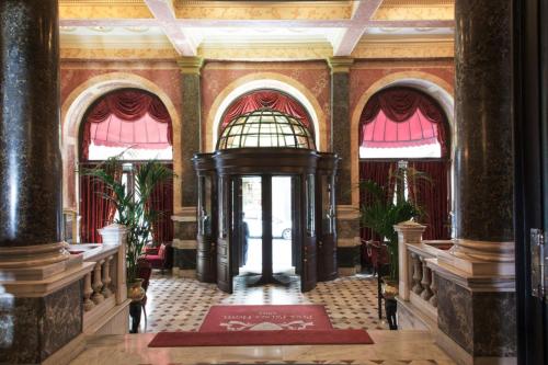a large room with a large staircase leading to a balcony at Pera Palace Hotel in Istanbul