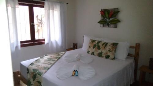 a bedroom with a bed with towels on it at Pousada Penedo in Penedo