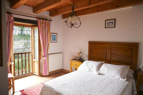 Un dormitorio con una cama y una ventana grande. en Hotel Rural La Puebla, en Orbaneja del Castillo