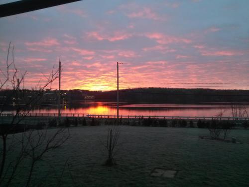 a sunset over a body of water with a pier at Domaine de la Baie, Les Suites in Shawinigan