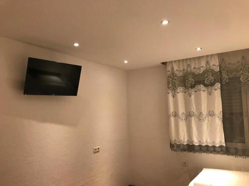 a living room with a television on the wall at TU Ferienzimmer in Ulm Stadtmitte in Ulm