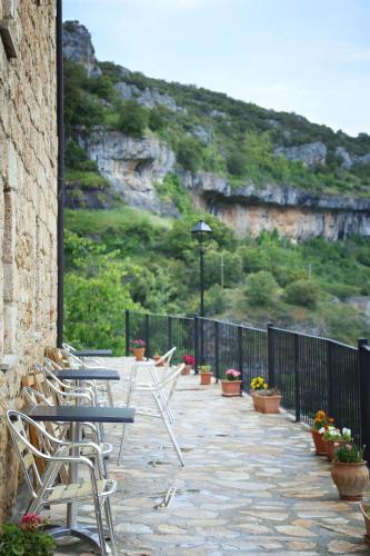 a row of chairs and tables on a patio with a mountain at Hotel Rural La Puebla in Orbaneja del Castillo