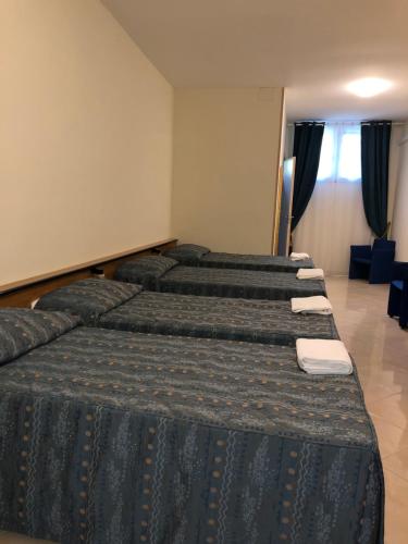 a group of four beds in a room at Hotel Chopin in Fiumicino