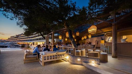 a group of people sitting at a restaurant at night at Lavica Seaside Apartments, Podstrana in Podstrana