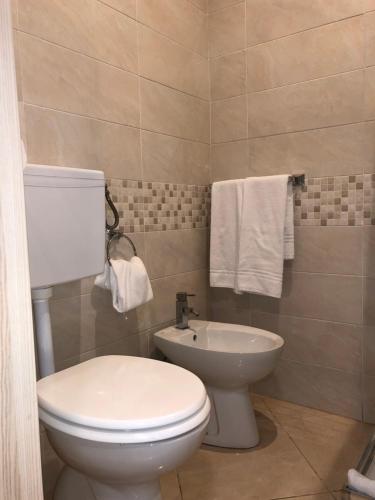 a bathroom with a white toilet and a sink at Hotel Chopin in Fiumicino