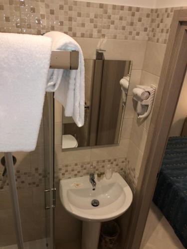 a bathroom with a sink and a mirror and towels at Hotel Chopin in Fiumicino