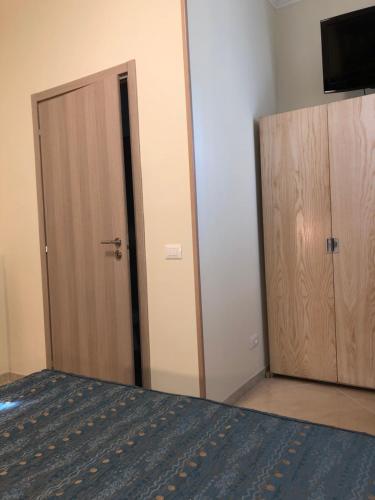 a bedroom with a bed and a closet and a door at Hotel Chopin in Fiumicino