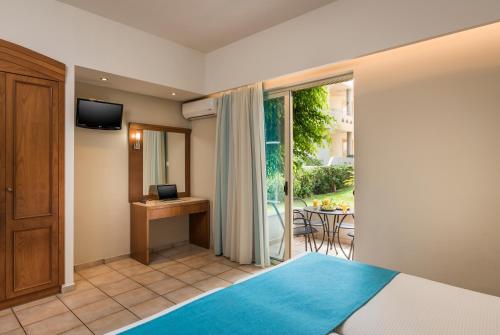 a bedroom with a bed and a view of a balcony at Elotis Suites in Agia Marina Nea Kydonias