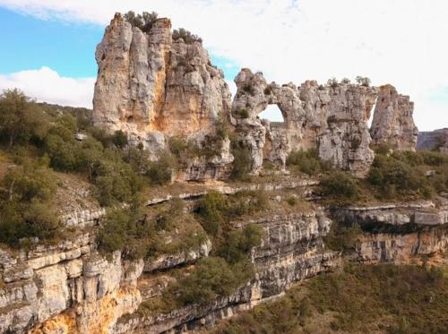a view of a rocky mountain with an arch on it at Hotel Rural La Puebla in Orbaneja del Castillo