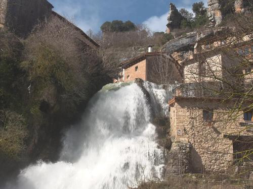 a waterfall on the side of a mountain at Hotel Rural La Puebla in Orbaneja del Castillo