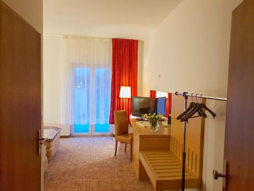 a hotel room with a desk and a television at Noclegi Portowa in Opole