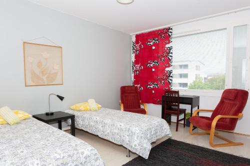 トゥルクにあるApartment Turku City Center host by B&B Tuureのベッド2台とテーブルと椅子のある寝室