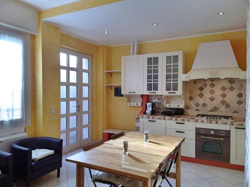 une cuisine avec une table en bois et une salle à manger dans l'établissement ALASSIO Trilocale a 50mt dal mare, à Alassio