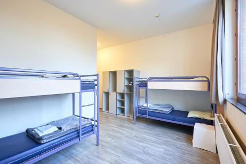 a room with two bunk beds in a dorm room at HI Brussels Generation Europe Hostel in Brussels