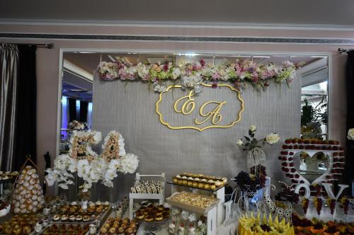 a dessert table with a sign and flowers on a wall at Hotel Nevada in Constanţa