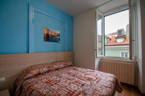 Un dormitorio con una cama y una ventana grande. en B&B DREAM, en Trieste