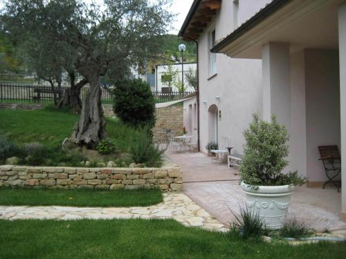 un patio con un árbol y una pared de piedra en Altrocanto, en Farindola