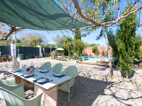 una mesa y sillas bajo una tienda cerca de una piscina en Holiday Home Ave de Paso by Interhome, en Fortià