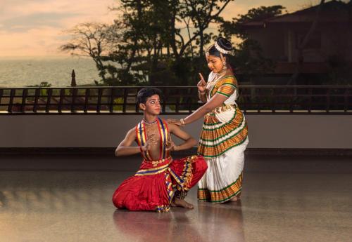 a woman standing next to a man on a dance floor at Niraamaya Wellness Retreats Backwaters And Beyond Kumarakom in Kumarakom