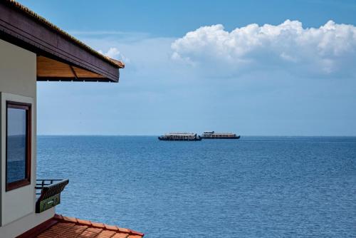 a view of the ocean with two ships in the distance at Niraamaya Wellness Retreats Backwaters And Beyond Kumarakom in Kumarakom