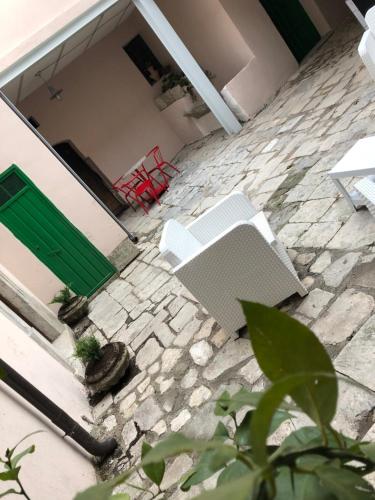 a patio with two white chairs and a green door at Boutique Hotel Palazzo Corso Umberto in Boiano